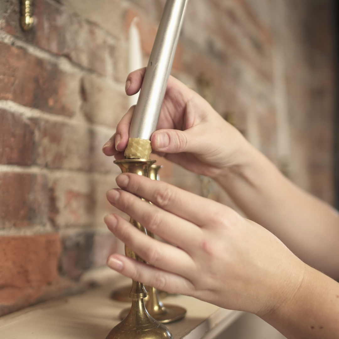 Beeswax fitter strip wrapped around taper candle so it fits into candlestick holder