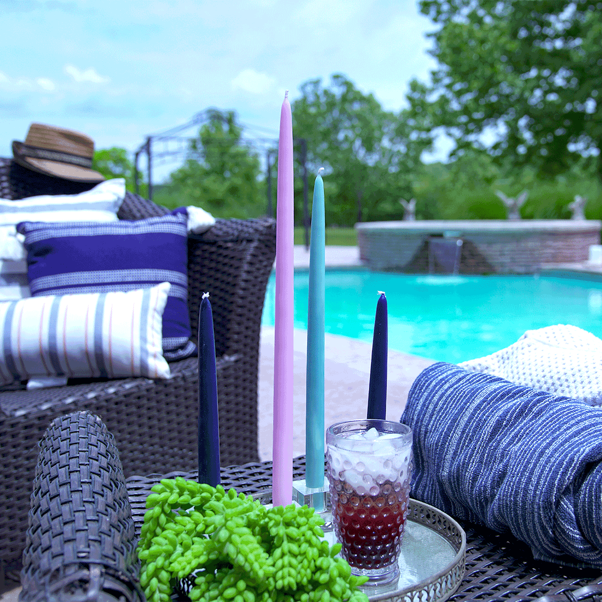 Taper candles of different lengths, as decoration for a pool deck table