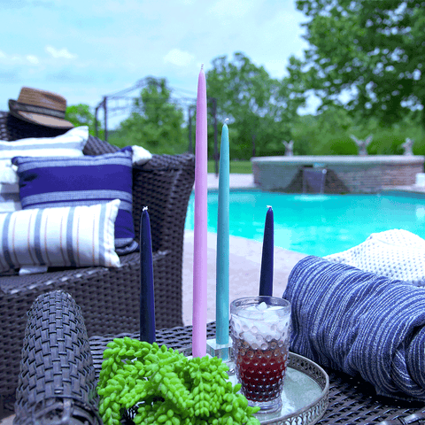 Taper candles of different lengths, as decoration for a pool deck table