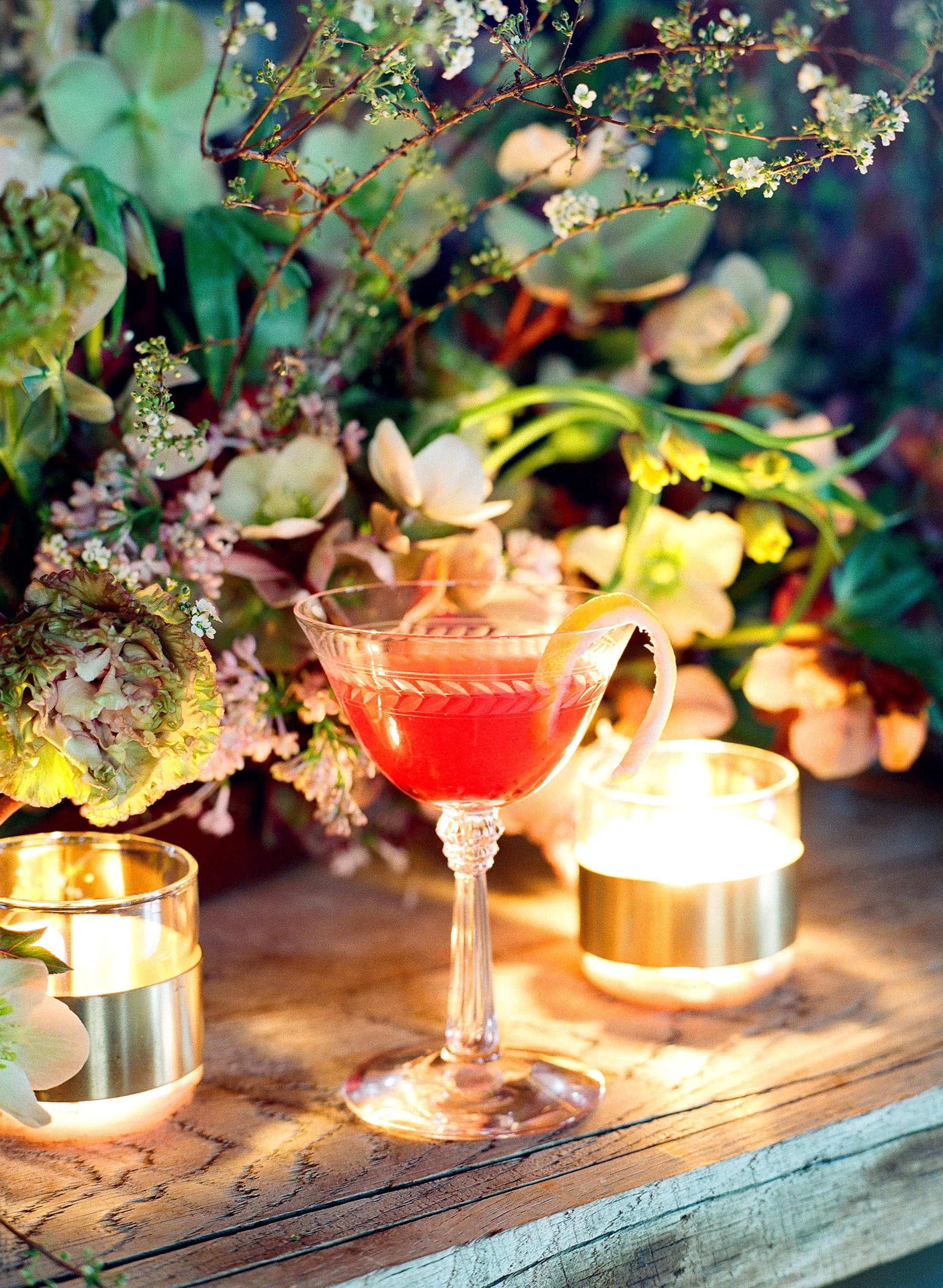 Spring cocktail and florals with lit tea lights